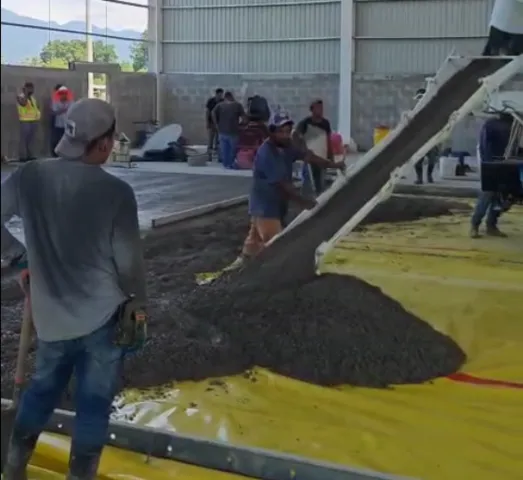 Equipo colocando concreto en un piso industrial