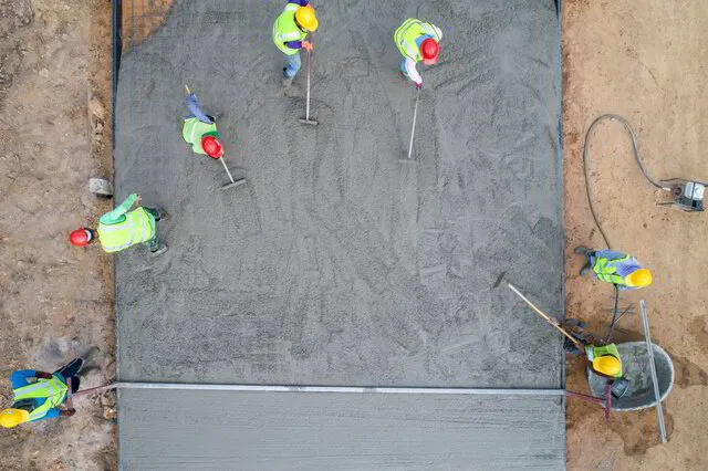 Equipo de construcción trabajando sobre una losa de concreto